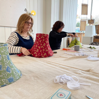 Two women making traditional lampshades during a workshop in brighton