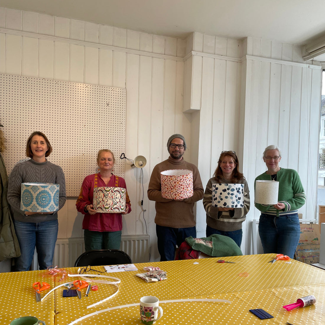 Five people holding their lampshades that they have just made during a workshop, Brighton