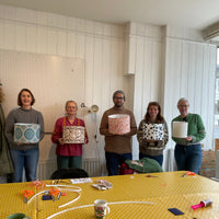 Five people holding their lampshades that they have just made during a workshop, Brighton