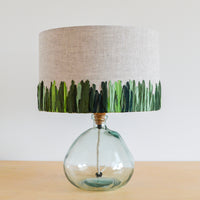 Green meadow embroidered linen lampshade paired with a hand blown glass lamp base