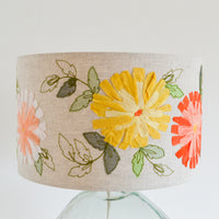 Linen lampshade featuring yellow embroidered flowers with green leaves 