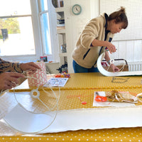 Two people making lampshades during a workshop 